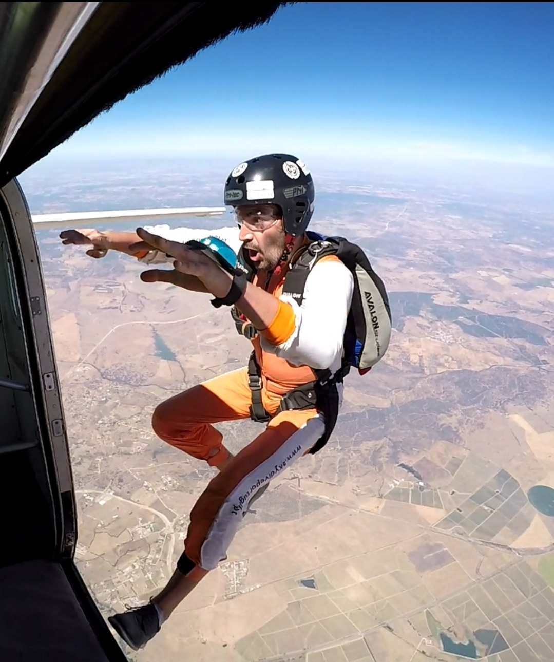 Skydiver leaving the aircraft over farmland