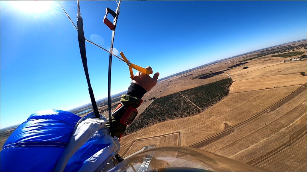 A peaceful, sunny view from under the parachute canopy after the scary part is over, showing the calm and euphoric reward of completing a skydive.