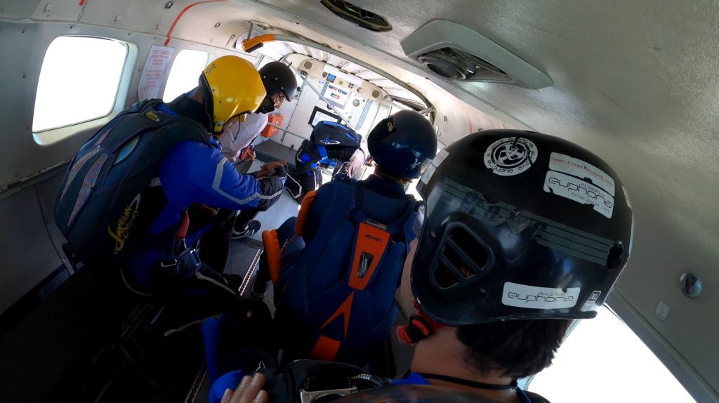 Skydivers sitting inside a rattling plane, experiencing the pre-jump fear and anticipation that is often the scariest part of a first skydive.